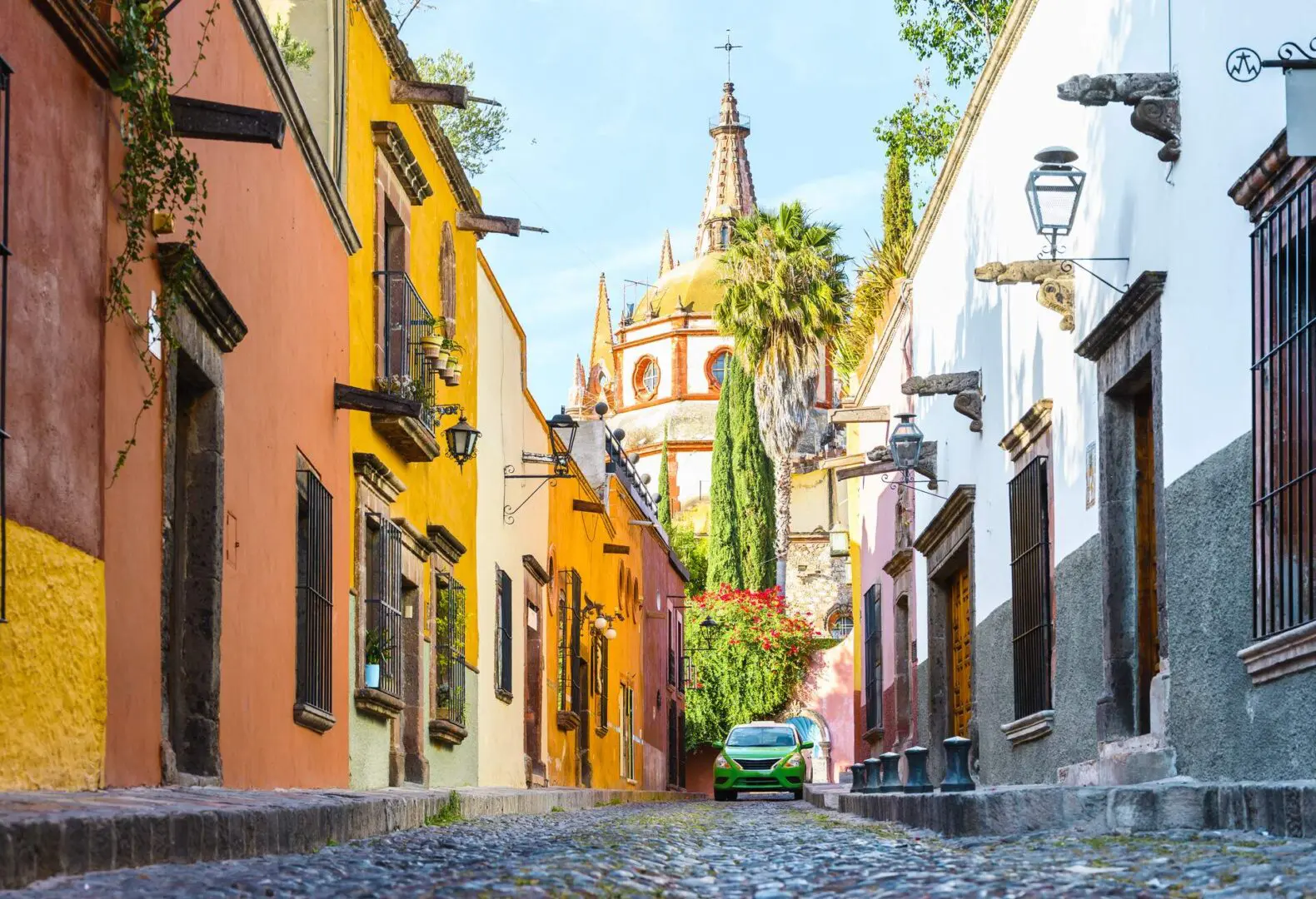 67c9f353c3c0e_mexico_san-miguel- A street with many buildings and trees in the background