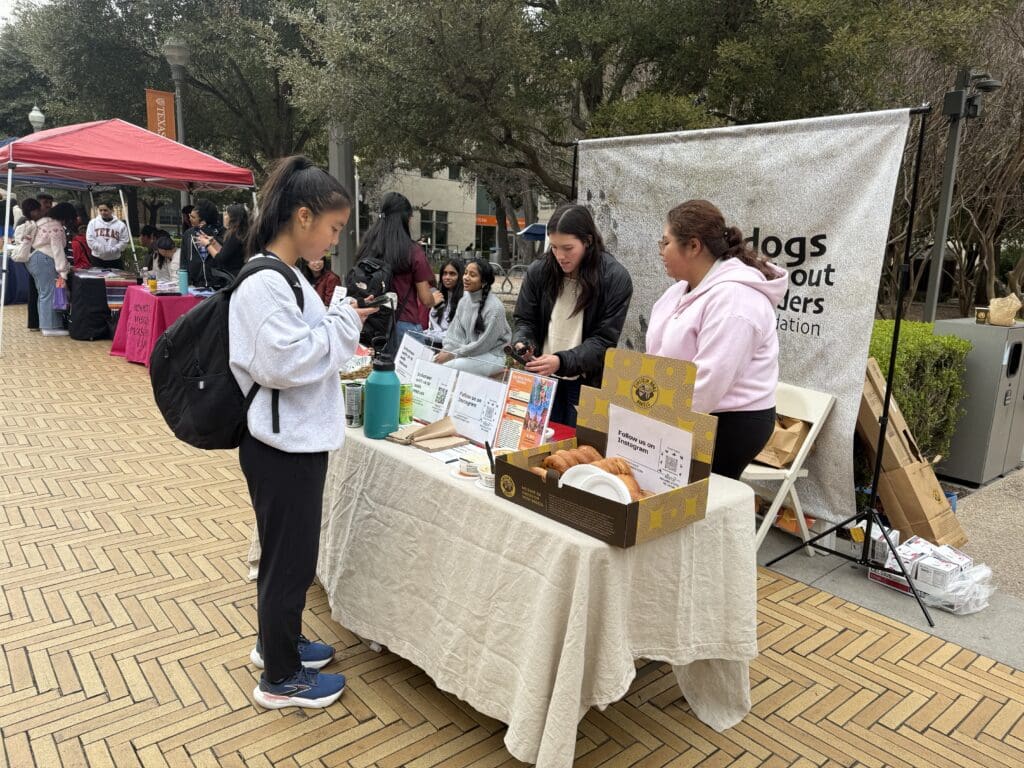 A group of people standing around a table with books.