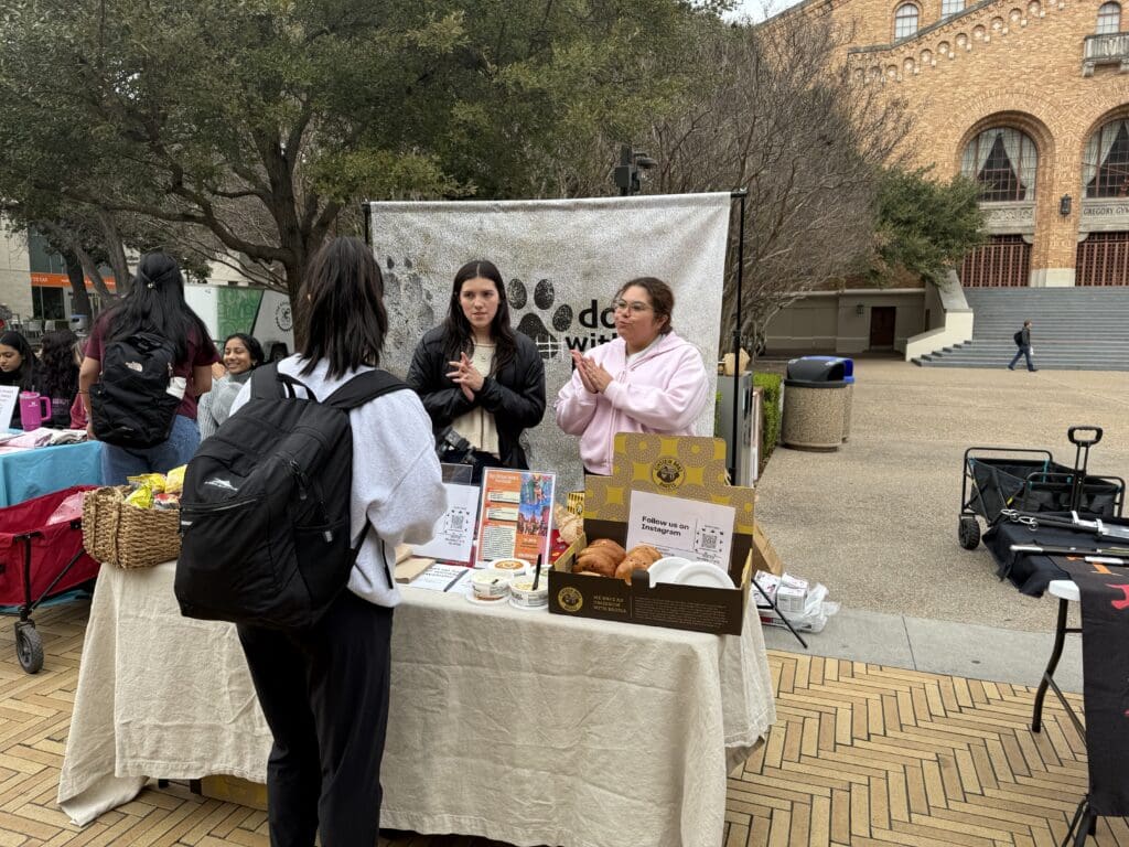 A woman standing next to a table with food.